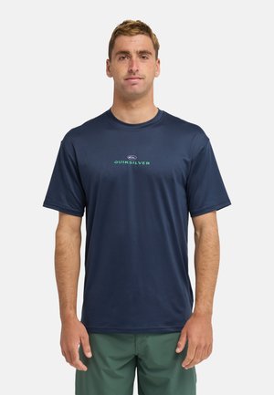 Marineblaues T-Shirt mit kurzen Ärmeln aus leichtem Stoff, mit einem grünen Quiksilver-Logo in der Mitte. Rundhalsausschnitt und lockere Passform.