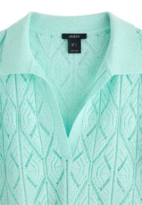 Top lavorato a maglia di un leggero verde menta, con scollatura a V e colletto corto. Presenta un motivo a diamante testurizzato su tutta la superficie. L'etichetta indica la taglia S.