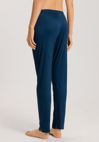 Pantalones de lounge azul marino hechos de una tela suave con un ajuste relajado, que cuentan con una cintura elástica y aberturas en los lados del tobillo para mayor libertad de movimiento.