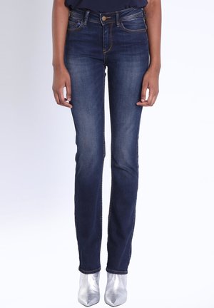 Jeans en denim bleu foncé avec une coupe slim, dotés d'un design classique à cinq poches et de coutures dorées métalliques. Fini avec une taille mi-haute.