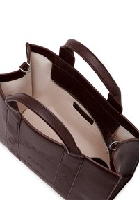 Brun strukturert lær totebag med doble håndtak, beige interiør og en glidelåsinnvendig lomme. Prentet merkevare på utsiden.