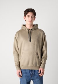 Sweatshirt khaki com capuz, bolso frontal, fecho com cordão e punhos canelados. Textura suave com um pequeno detalhe de logótipo na bainha.
