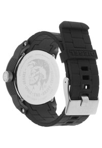Black rubber strap watch with stainless steel back, round case, textured surface, silver buckle, and engraving of a face design.