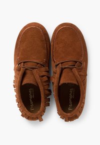 Bruine suède moccasinschoenen hebben een ronde neus, franjes aan de zijkanten en een vetersluiting voor een verstelbare pasvorm.