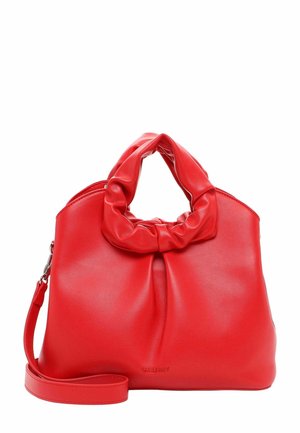 Sac à main en cuir rouge avec une anse nouée, texture lisse et une bandoulière amovible. Présente un branding minimal sur le côté.