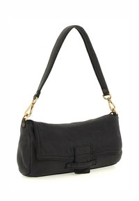 Borsa a tracolla nera in pelle con una forma piatta, una maniglia corta, accessori in oro e un evidente pattina frontale con un punto a fiocco. Texture liscia.