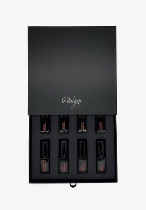 Boîte cadeau noire avec une finition mate lisse, l'intérieur contient huit petits flacons de parfum noirs, étiquettes orange, avec différents noms.
