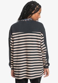 Long-sleeve shirt featuring dark green and beige horizontal stripes, round neckline with patterned detail, and relaxed fit.