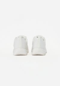 Λευκά αθλητικά παπούτσια με υφασμάτινη επάνω επιφάνεια με υφή, με επενδεδυμένο κολάρο και ευλύγιστη καουτσούκ σόλα, διαθέτουν θηλιά για εύκολη φόρμα στο τακούνι.