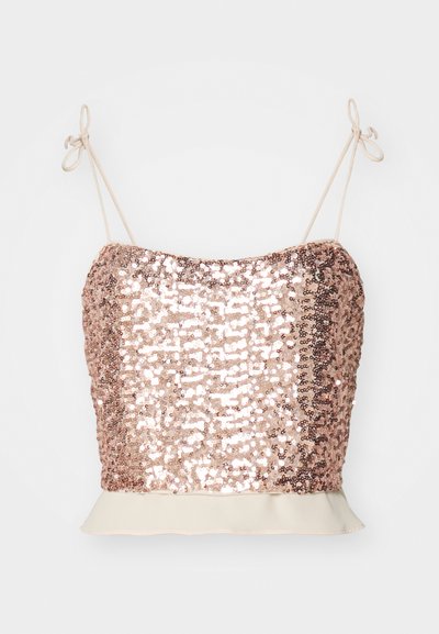 Camisole en sequins dorés rose avec des bretelles réglables et un ourlet peplum crème. Surface texturée avec des détails brillants et réfléchissants.