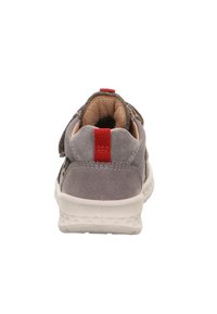 Graue Wildledersneaker mit gepolstertem Kragen, einem roten Akzentgurt auf der Rückseite und einer strukturierten weißen Gummisohle.