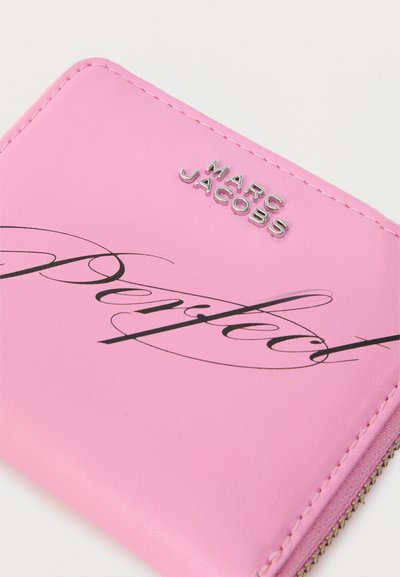 Ροζ δερμάτινο πορτοφόλι με ασημένιο λογότυπο "MARC JACOBS" και μαύρο κειμενογράφημα «Perfect», ραμμένες άκρες και ορατό φερμουάρ.