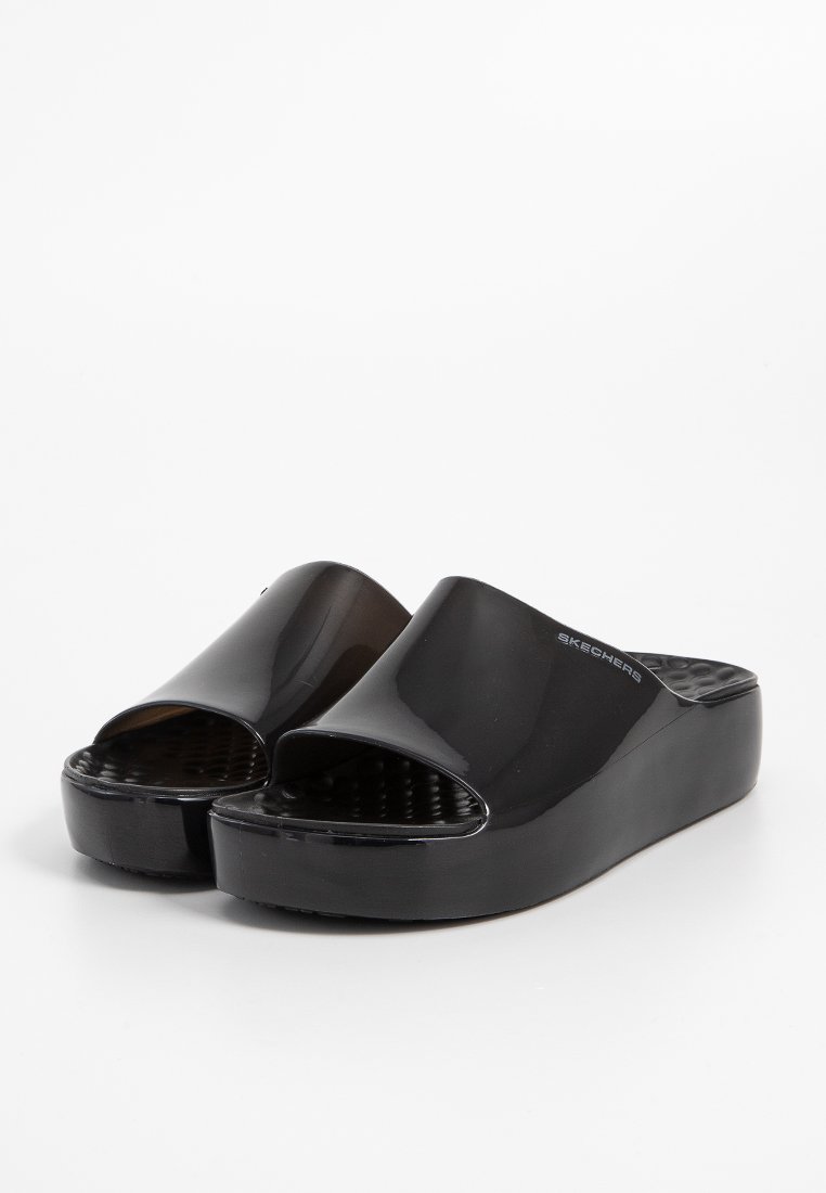 Schwarze Plattform-Sandalen mit glatter, glänzender Oberfläche, Offene-Zehen-Design und strukturiertem Fußbett mit Skechers-Logo an der Seite.