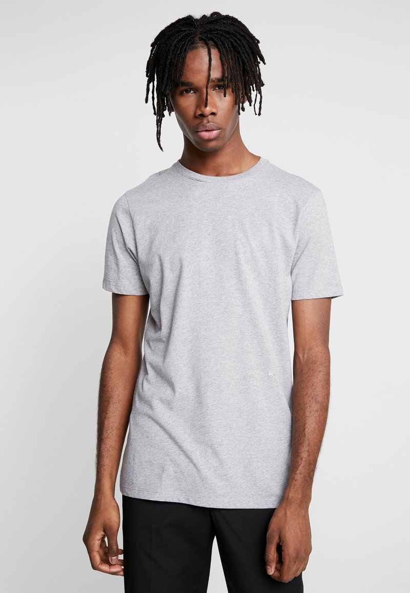 Szary t-shirt z okrągłym dekoltem wykonany z bawełnianej mieszanki, z krótkimi rękawami i luźnym krojem, z minimalnym logo z przodu na dole.
