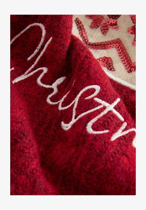 Piros textúrált szövet fehér írott hímzéssel és bézs folttal, melyet piros flitterek díszítenek csillagmintában.