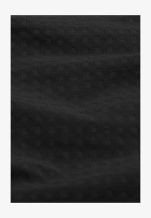 Teksturoitu musta kangas, jossa on pieniä, koholla olevia pyöreitä kuvioita. Materiaali näyttää pehmeältä ja siinä on sileä, hieman kiiltävä pinta.