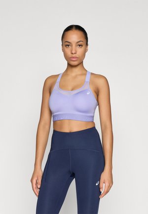 Lyse lilla sports-bh med en jevn tekstur, brede stropper og rund halslinning, med en logobånd nederst.