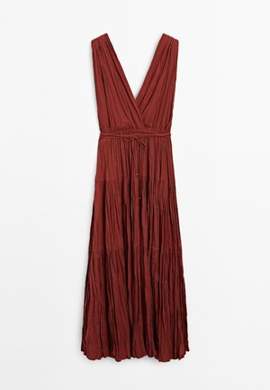 Robe longue à décolleté en V profond, de couleur rouille, avec des plis et une taille à nouer, suspendue contre un fond blanc. Pas de motifs ni de décorations visibles.