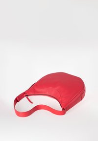 Rode leren schoudertas met een gladde textuur, ronde vorm en een enkele verstelbare strap. Voorzien van een ritsluiting aan de bovenkant.