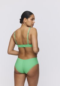 Groene bikini set met een schulpdesign aan de bandjes, zachte textuur en een middelhoge bikinibroek. De sluiting bevindt zich aan de achterkant met verstelbare bandjes.