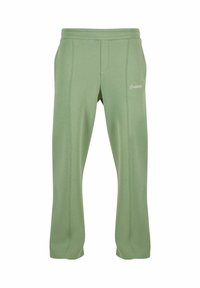 Groene katoenen sweats met een elastische tailleband, zijzakken en decoratieve stiksels. Tekst "Verboden" in het wit op de dij.