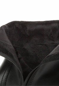 Zwarte leren laars met een zachte zwarte imitatiefleece voering. Heeft een ritssluiting aan de zijkant en zichtbare stiksels langs de randen.