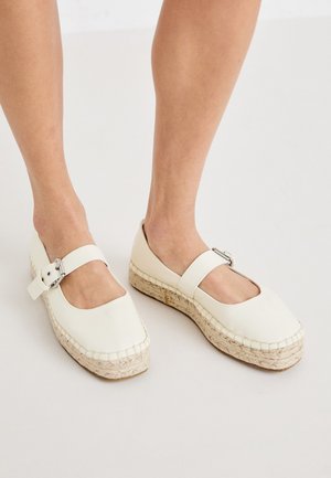 Valged nahast espadrilles stiilis kingad ruudukujulise varbaga, reguleeritava pandlaga ja punutud jute tallaga. Sile tekstuur ja puhtad jooned.