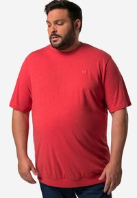 T-shirt rosso a maniche corte con collo tondo, realizzato in tessuto morbido. Presenta un sottile logo "M" sul petto e una vestibilità rilassata.