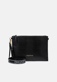 Svart läderclutch med krokodilprägling och guldlogotyp, med ovansidan dragkedja och justerbar rem med logotryck. Slät textur.