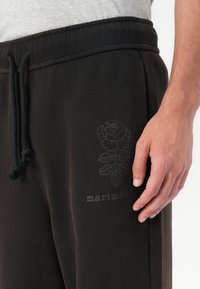 Marimekko PUUSKA VIHKIRUUSU PLACEMENT UNISEX - Tracksuit bottoms - dark brown