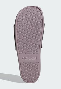 Fialová gumová podrážka s textúrovaným vzorom, na ktorej je vylisované meno značky "adidas". Dizajn je plochý s zaoblenou špičkou a pätou.