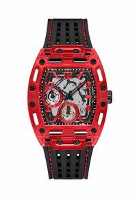 Reloj con caja transparente roja y correa de goma negra. La esfera cuadrada presenta un fondo gris, acentos rojos y marcadores de hora negros.