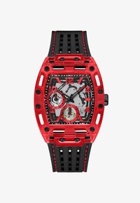 Reloj con caja transparente roja y correa de goma negra. La esfera cuadrada presenta un fondo gris, acentos rojos y marcadores de hora negros.