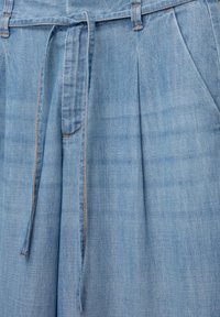 Lyseblå denimshorts med snor i taljen, prydet med frontfolder, sidelommer og orange syninger.