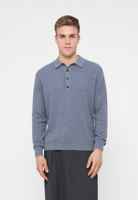 Langärmliges Poloshirt in meliertem Blau, aus strukturierter Strickware. Mit einem Kragen und einer Drei-Knopf-Leiste. Schlanker Schnitt.
