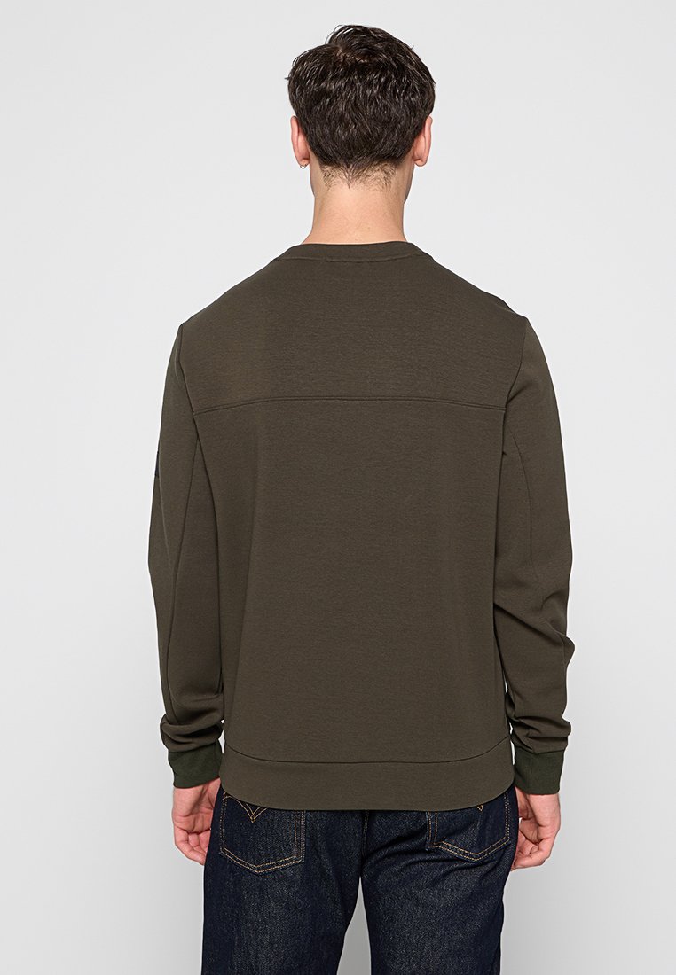 Felpa verde scuro con maniche lunghe, collo rotondo e polsini a costine. Tessuto liscio con un design minimalista e senza loghi visibili.