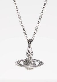 Sølvkjede med et anheng formet som en juvelbesatt planet med ringer og et lite kors på toppen.