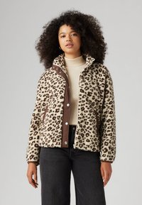 Μπεζ φλις μπουφάν σε λεοπάρ σχέδιο με καφέ κουμπιά τύπου τσιμπιδάκι στο μπροστινό μέρος και γιακά. Διαθέτει πλαϊνές τσέπες και ριμπ μανσέτες.