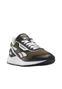 Teniska Reebok v olivově zelené a černé textilii s bílými detaily, výrazným logem, členitou podrážkou a klasickým atletickým designem.