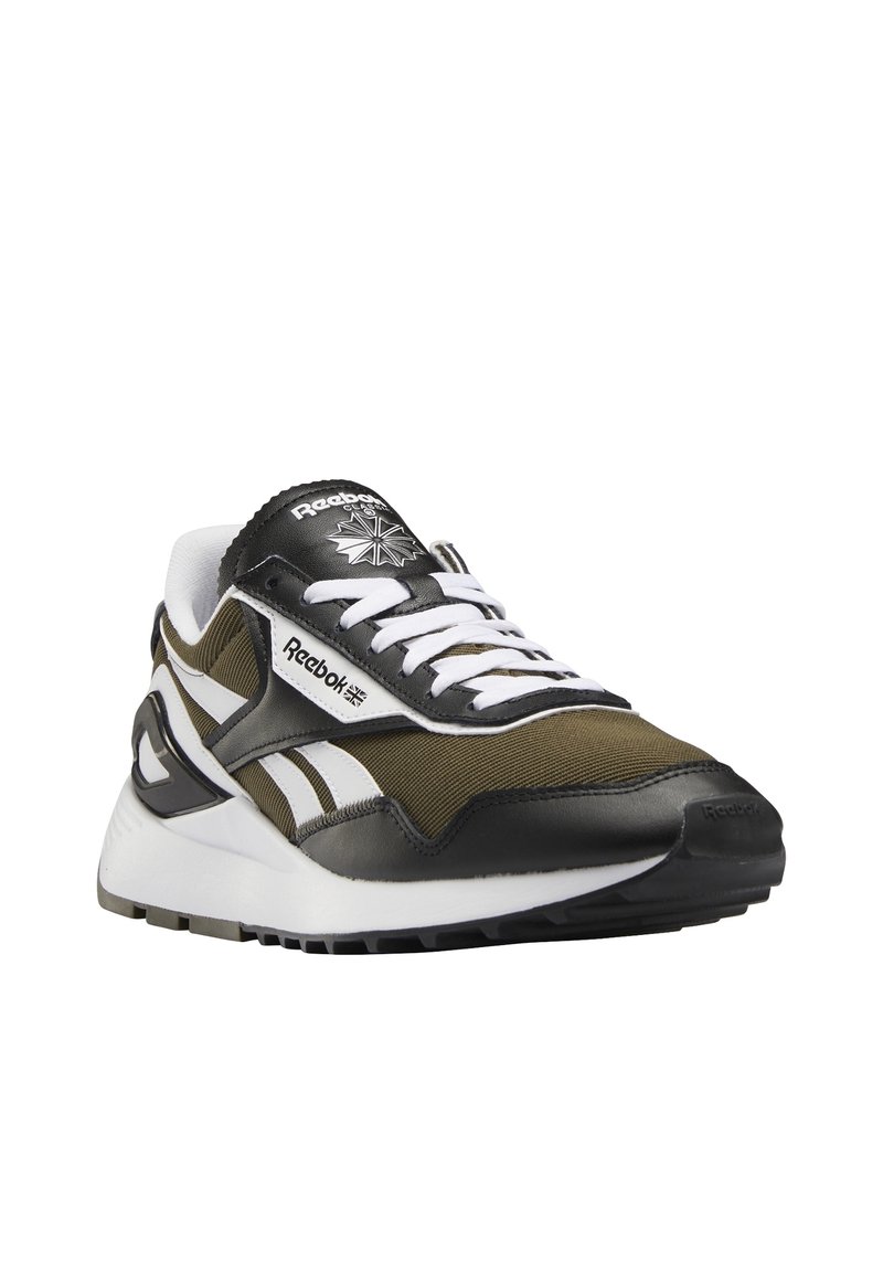 Teniska Reebok v olivově zelené a černé textilii s bílými detaily, výrazným logem, členitou podrážkou a klasickým atletickým designem.