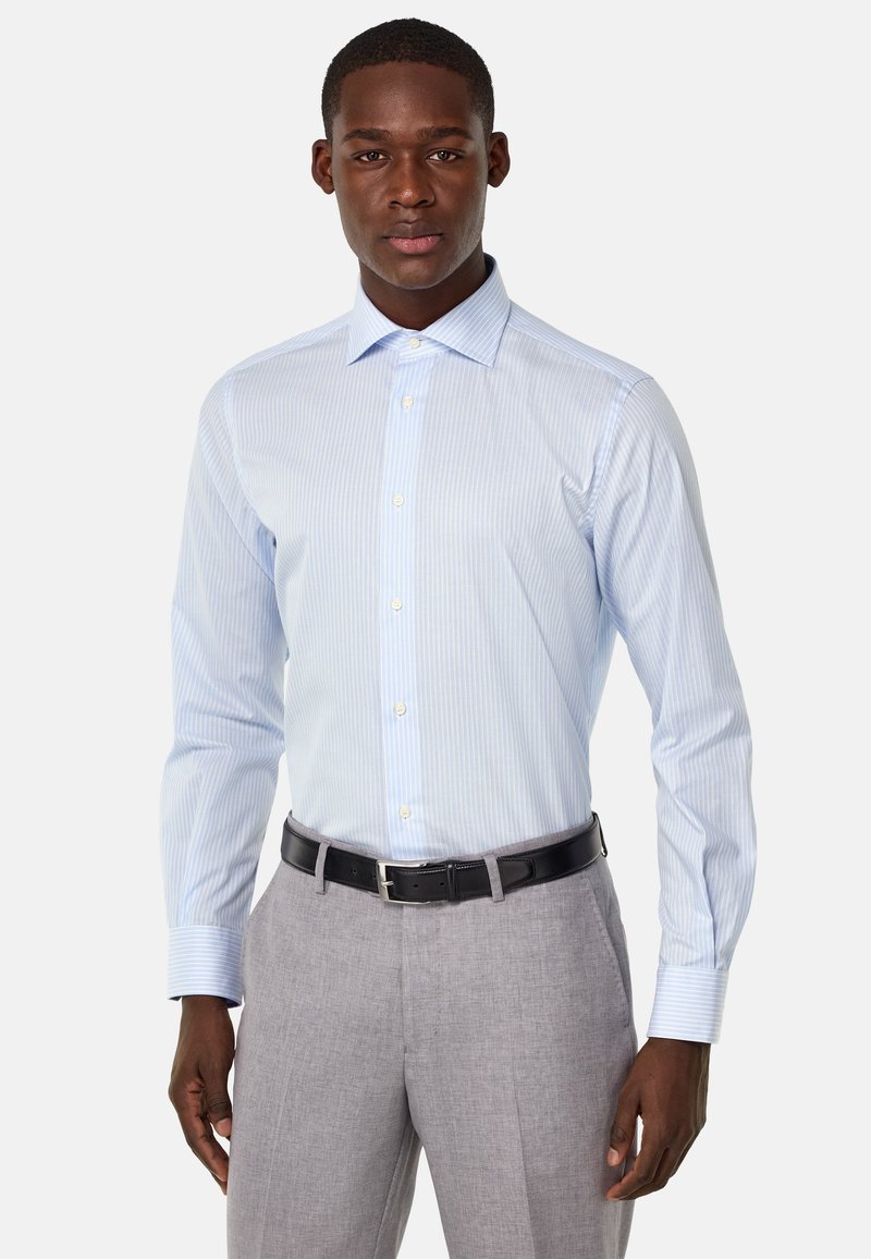 Camisa de vestir a rayas azul claro y blanca con cuello spread y mangas largas, combinada con pantalones grises y un cinturón negro.