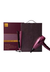 Zestaw deluxe GHD z bordową etui w wzór krokodyla, suszarką do włosów w kolorze czereśni oraz prostownicą z czarnym akcentem i detalem w postaci przycisku.