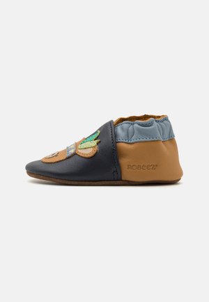 Leather baby shoe in navy, tan, and light blue; features an embroidered design with animal accents; soft, flexible sole; elastic opening.