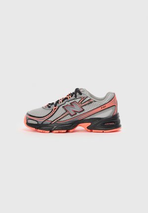 Chaussure de sport avec une tige en mesh gris ornée d'accents noirs et orange, semelle rembourrée, bout arrondi et marquage de la technologie ABZORB.