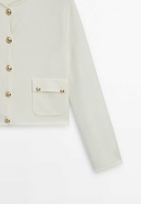 Cream-colored cropped jacket with long sleeves, featuring gold-button closure and a single chest pocket with a matching button detail.