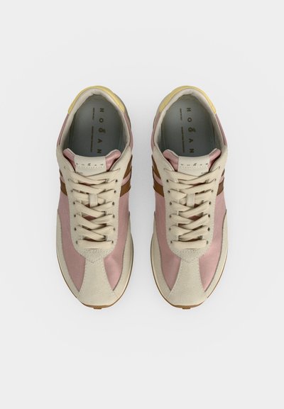 Ζευγάρι μπεζ και ροζ αθλητικά με κορδόνια, καφέ πλευρικές ρίγες, κίτρινες λεπτομέρειες στη φτέρνα, από πάνω σε απλό φόντο.