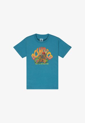 Jasnoniebieska bawełniana koszulka z kolorową grafiką, w połączeniu z jasnymi dżinsowymi szortami i czarno-białymi tenisówkami.