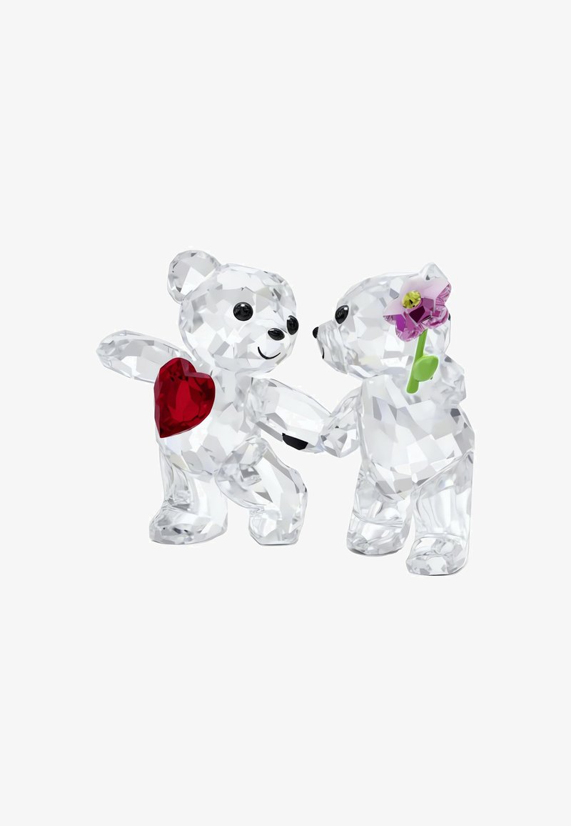 Due due figurine di orso in cristallo che si tengono per mano, una con un cuore rosso sul petto e l'altra che tiene un fiore rosa, con dettagli lucidi e sfaccettati.