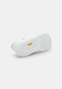 White sneaker with a textured rubber sole, featuring a Vibram logo. Smooth upper with a subtle design, emphasizing minimalism and durability.