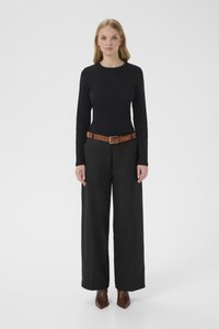 Must pikkade varrukatega liibuv ülaosa ümmarguse kaelusega, kombineeritud kõrge vöökohaga laia säärega mustade pükstega ja pruun nahast vööga. Pruunid teravnurksed pahkluu saapad.